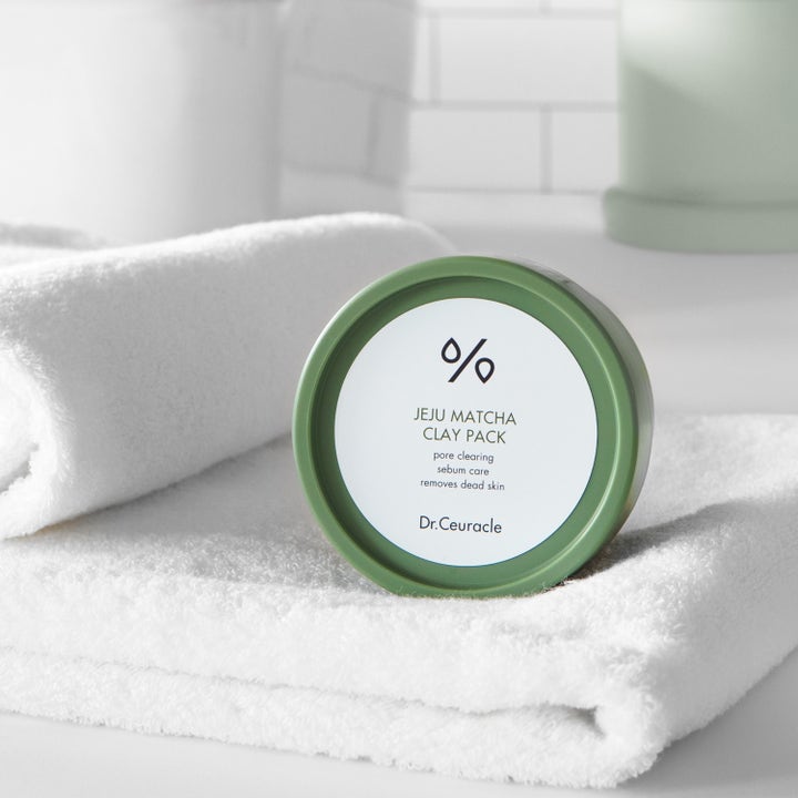 Dr. Ceuracle Jeju Matcha Clay Mask 115 g pore clearing ansigtsmaske i grøn krukke på et hvidt håndklæde