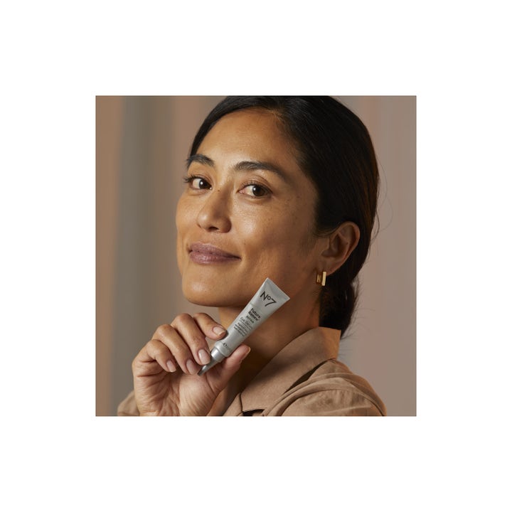 No7 Future Renew Repair Eye Serum 15 ml reparerende øgonserum i sølvtube holdt op mod ansigtet af en kvinde