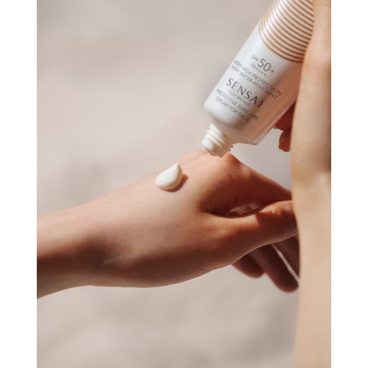 Sensai Silky Bronze Protective Cream Face 50 ml solcreme med SPF 50 påføres i en cremet konsistens på en hånd.