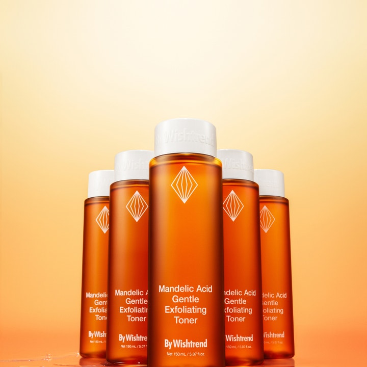 By Wishtrend Mandelic Acid Gentle Exfoliating Toner 150 ml eksfolierende toner i fem ravfarvede flasker mod orange baggrund