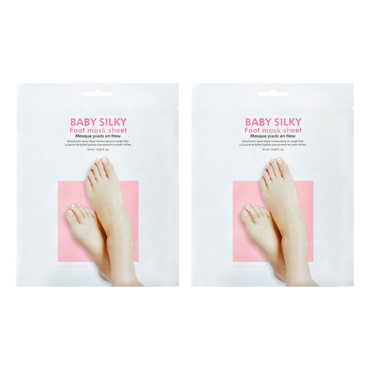 Holika Holika Baby Silky Foot Mask Sheet 18 ml fugtgivende fodmaske i hvide breve med billede af fødder og pink detaljer.