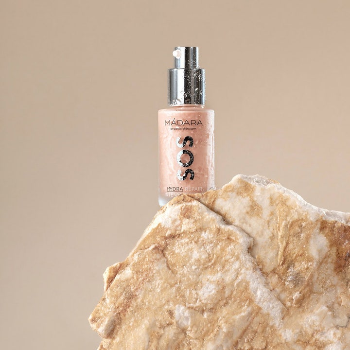 MÁDARA SOS Hydra Repair Intensive Serum 30 ml fugtgivende serum i flaske med vanddråber på en naturlig sten