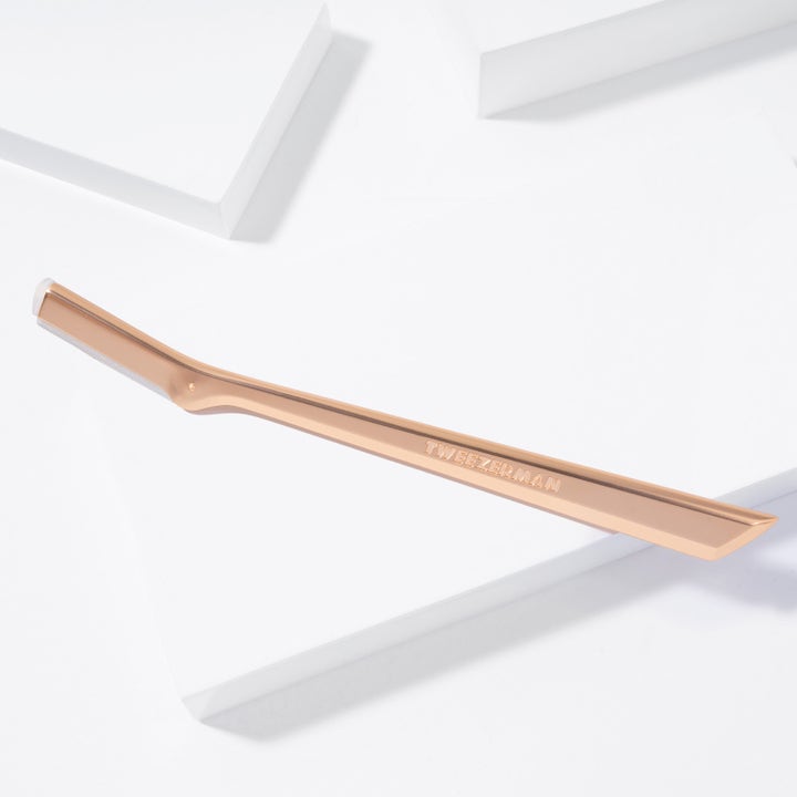 Tweezerman Facial Razor Rose Gold 1 stk ansigtsskraber fjerner uønsket ansigtshår i et elegant rose gold design på hvide blokke.