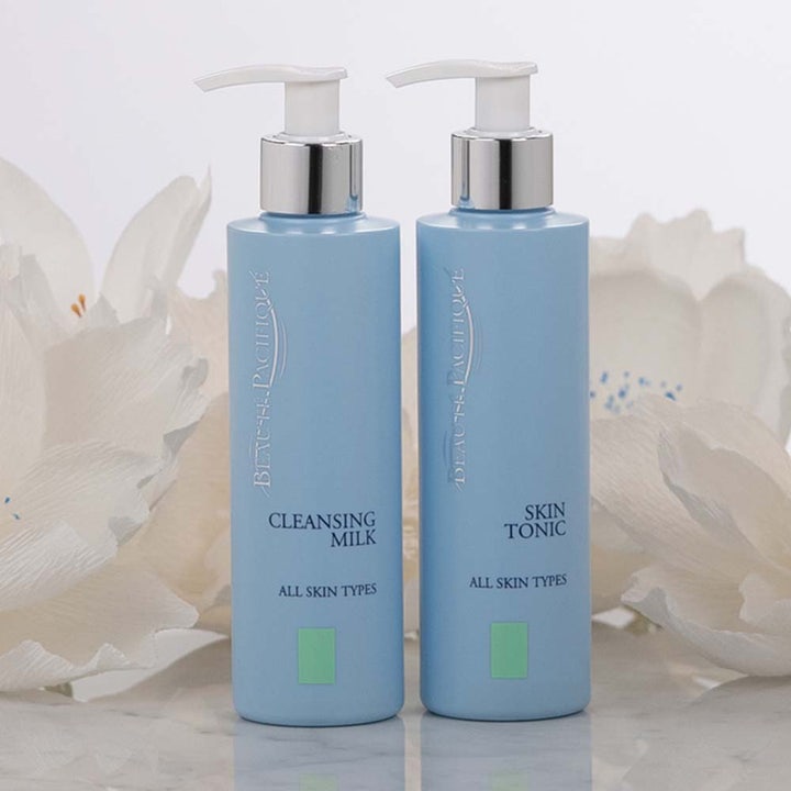Beauté Pacifique Cleansing Milk 200 ml mild ansigtsrens i lyseblå pumpeflaske foran hvide blomster
