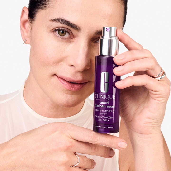 Clinique Smart Clinical Repair Serum 75 ml rynkekorrigerende serum i lilla flaske holdt af en kvinde
