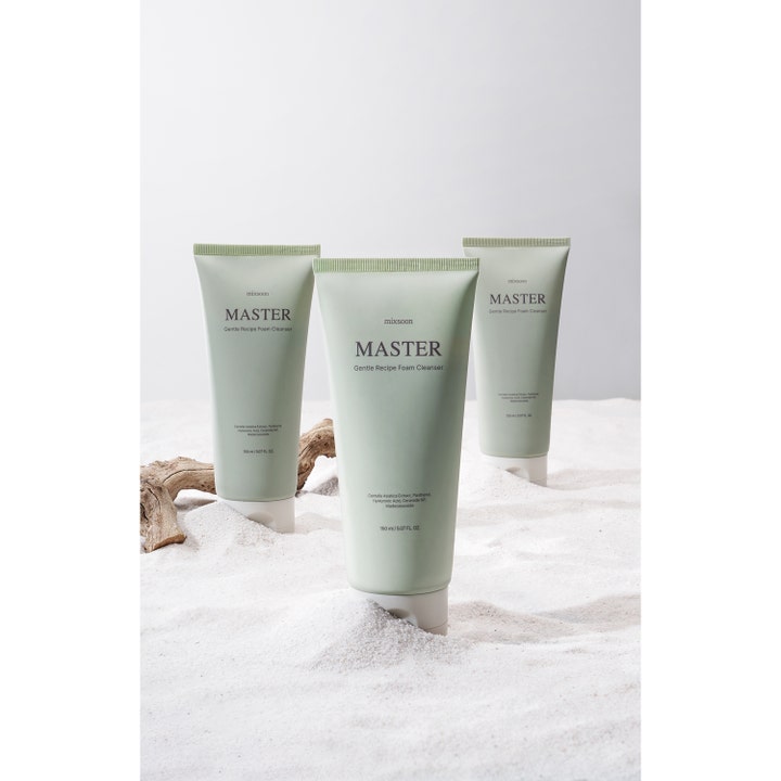 Mixsoon Master Gentle Recipe Foam Cleanser 150 ml beroligende rengøringsskum i grønne tuber i hvidt sand med drivtømmer.