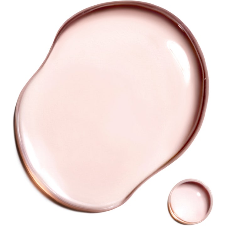 Clarins Super Restorative Treatment Essence 200 ml flydende tekstur i en lyserød dråbe til ansigtspleje
