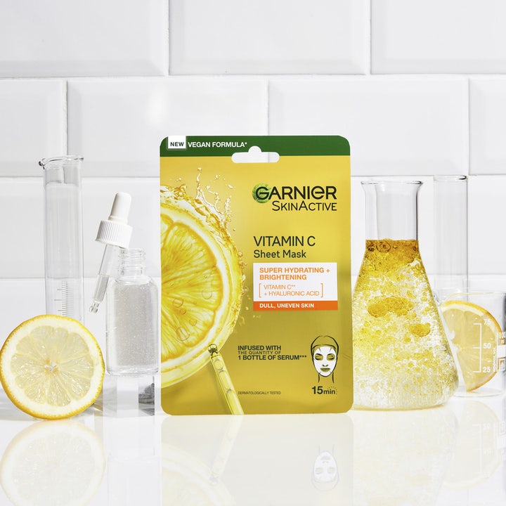 Garnier SkinActive Vitamin C Sheet Mask 28 g giver glød i et laboratoriemiljø med citroner og kolber.