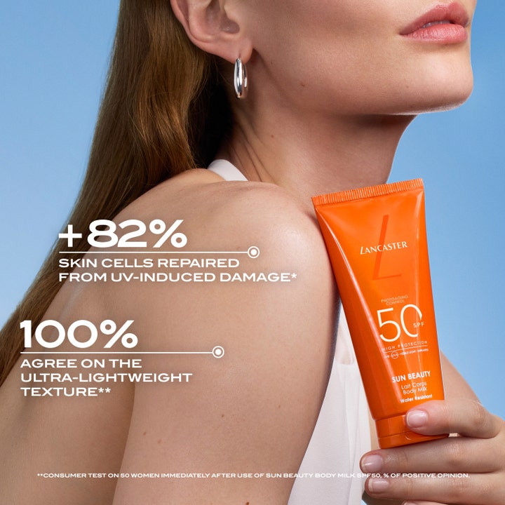 Lancaster Sun Beauty Body Milk SPF50 100 ml reparerende solcreme i orange tube holdt mod en bar skulder.