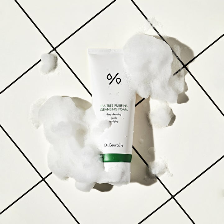 Dr. Ceuracle Tea Tree Purifine Cleansing Foam 150 ml rengøringsskum i hvid tube omgivet af luftigt hvidt skum.