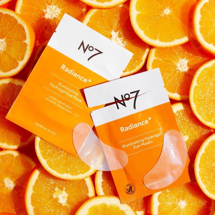 No7 Radiance+ Hydrogel Eye Masks 5 stk øjenmasker giver glød vist som orange breve på friske appelsinskiver.