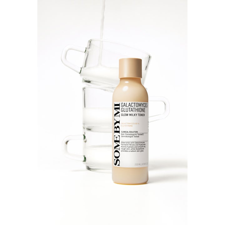Some By Mi Galactomyces Glutathione Glow Milky Toner 200 ml giver glød foran stablede glaskopper med mælket væske.