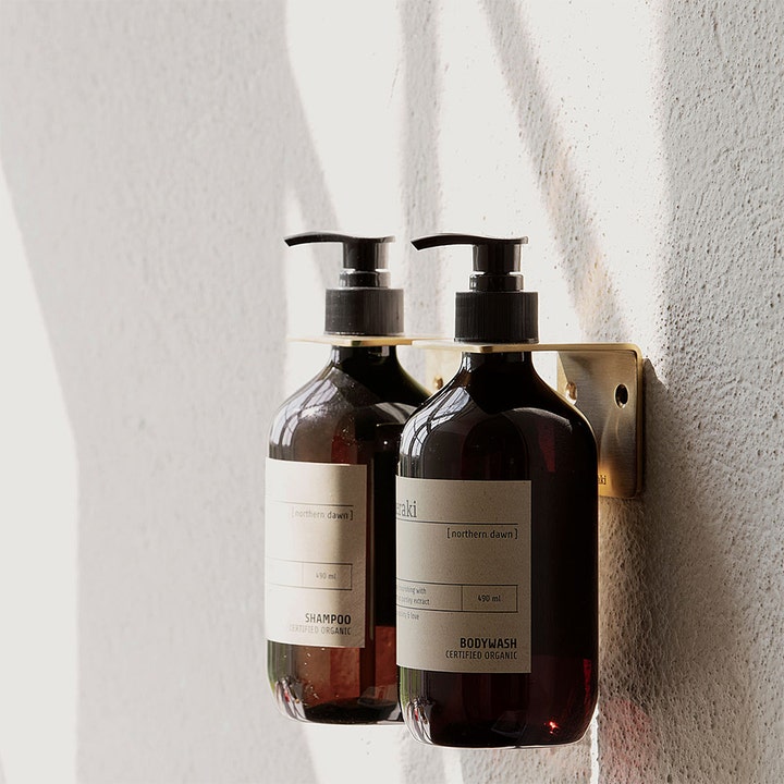 Meraki Northern Dawn Body Wash 490 ml plejende bodyshampoo i mørk pumpeflaske på et elegant messingbeslag