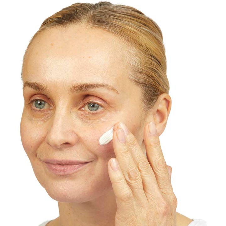 No7 Lift & Luminate Triple Action Day Cream 50 ml opstrammende dagcreme med SPF15 påføres af en kvinde.