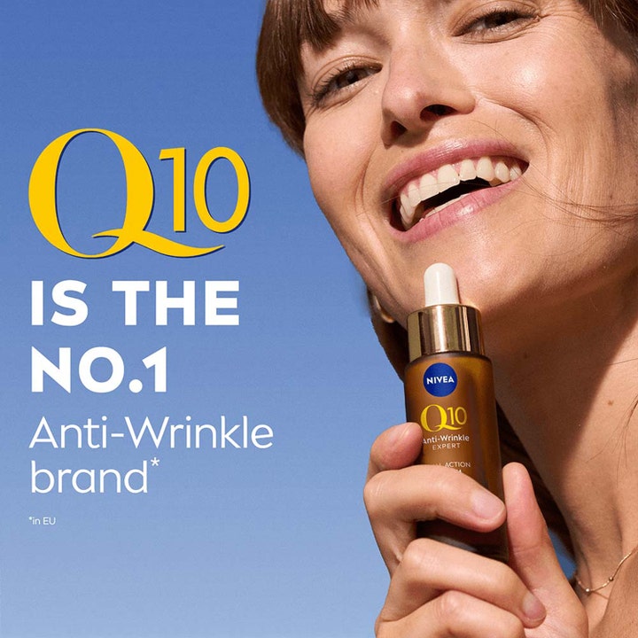 NIVEA Q10 Anti-Wrinkle Expert 30 ml serum mod rynker holdt af en smilende kvinde mod blå himmel