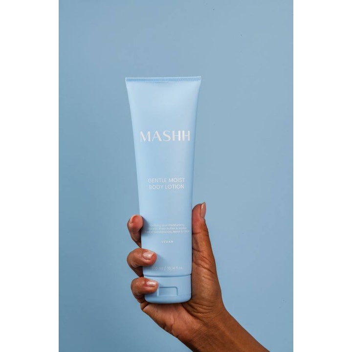MASHH Gentle Moist Body Lotion 300 ml fugtgivende vegansk bodylotion i lyseblå tube holdt af en hånd