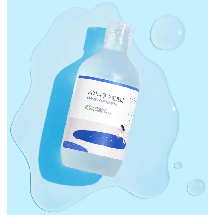Round Lab Birch Juice Moisturizing Toner 300 ml fugtgivende toner i klar flaske omgivet af vand på blå baggrund