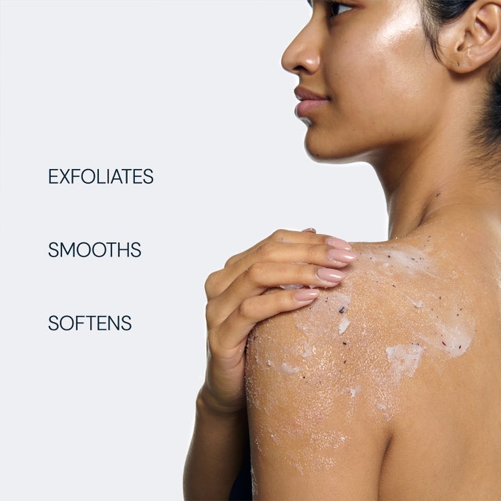 Elemis Frangipani Monoi Salt Glow 490 g eksfolierende body scrub på hud med tekst Exfoliates Smooths Softens.