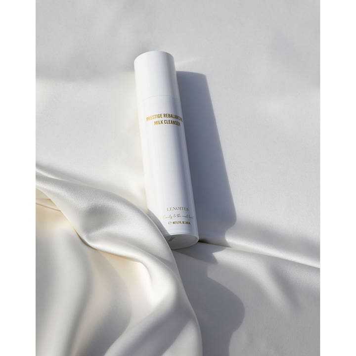Lenoites Prestige Rebalancing Milk Cleanser 200 ml mild rengøringsmælk i hvid flaske på hvidt silkestof