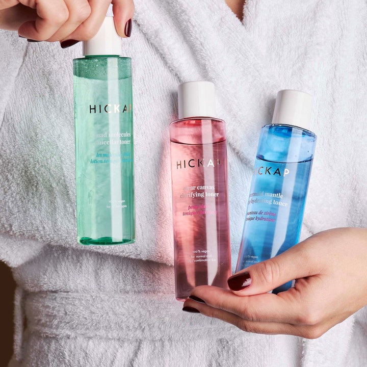Hickap Mermaid Mantle Deep Hydrating Toner 150 ml fugtgivende toner i blå flaske holdt af person i hvid morgenkåbe