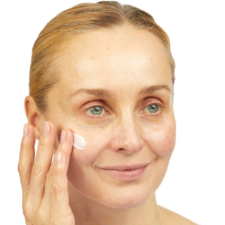 No7 Lift & Luminate Triple Action Night Cream 50 ml fastgørende nattcreme påføres af en kvinde på kinden