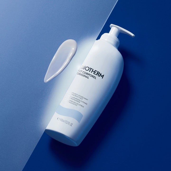 Biotherm Lait Corporel 400 ml fugtgivende bodylotion i hvid pumpeflaske med cremet tekstur på blå baggrund