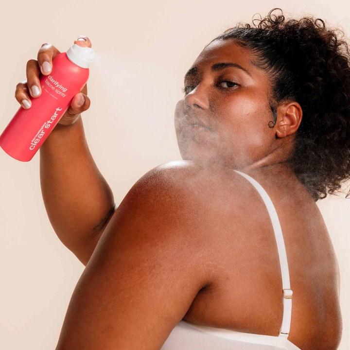 Dermalogica Clarifying Body Spray 177 ml mod urenheder sprayes på ryggen af en kvinde i hverdagsmiljø