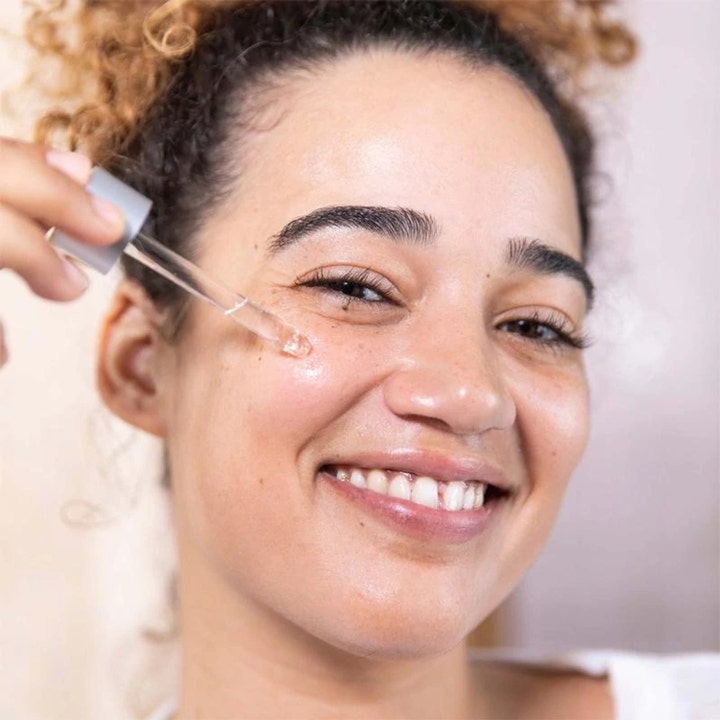 Dermalogica AGE Bright Clearing Serum 30 ml giver klarere hud og påføres med glaspipette på en smilende kvinde.