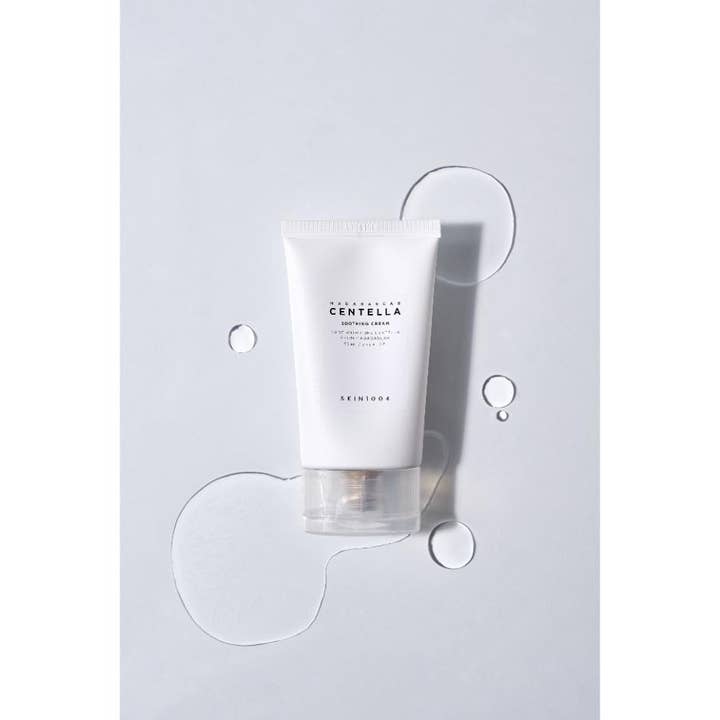 SKIN1004 Madagascar Centella Soothing Cream 75 ml beroligende dagcreme i hvid tube omgivet af klare dråber