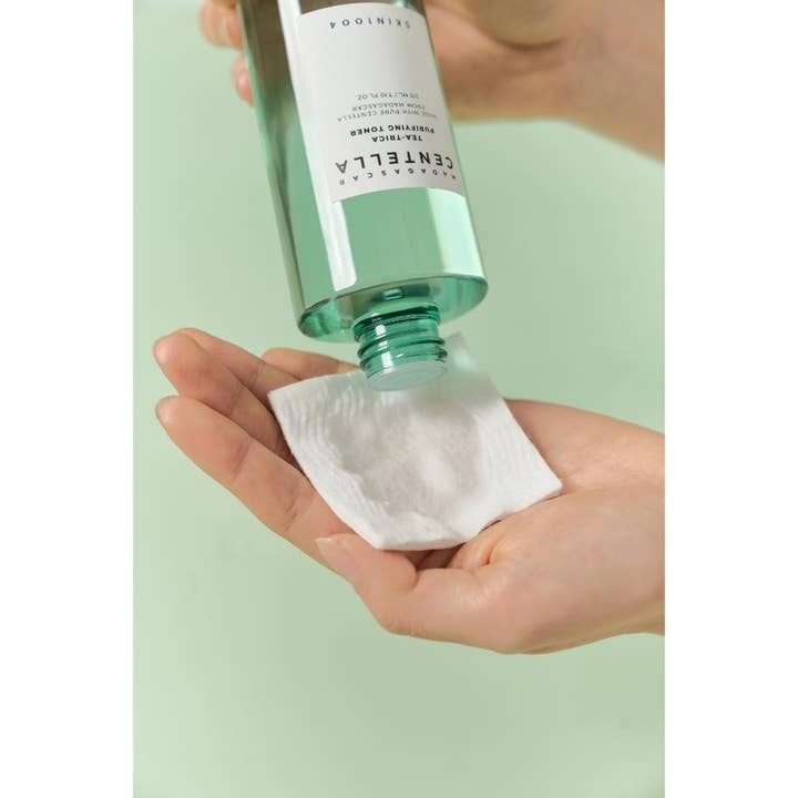 SKIN1004 Madagascar Centella Tea-Trica Purifying Toner 210 ml rensende toner hældes på en vatrondel fra en grøn flaske