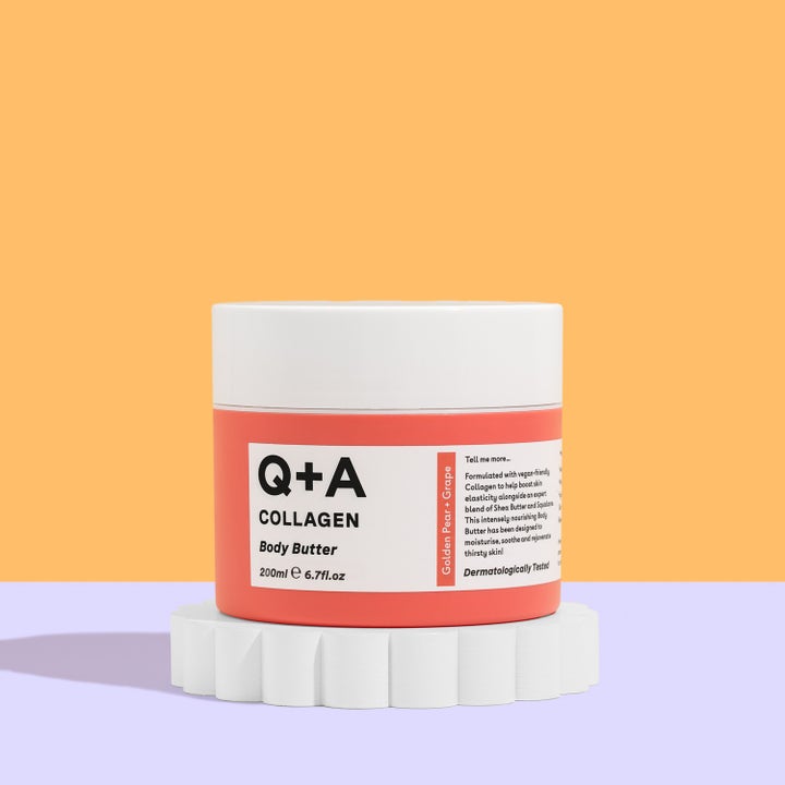 Q+A Collagen Body Butter 200 ml fugtgivende kropspleje i orange krukke med hvidt låg på en dekorativ base.