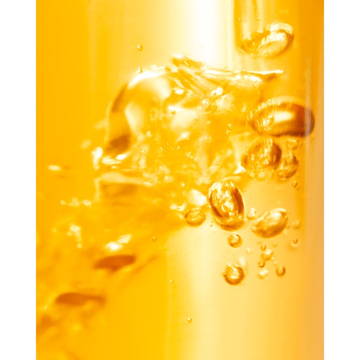Nuxe Tanning Sun Oil SPF50 150 ml sololie som giver glød med en gylden flydende tekstur og små bobler.
