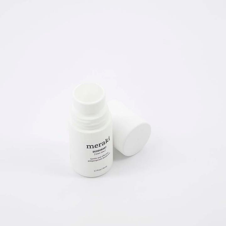 Meraki Deodorant Linen Dew 50 ml giver friskhed i en hvid roll-on flaske med låget placeret ved siden af