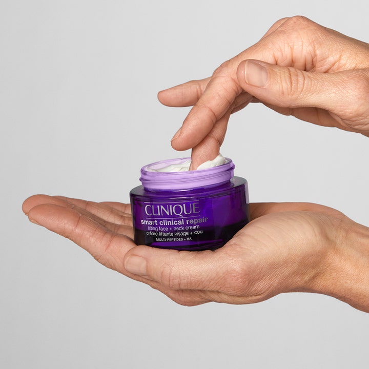 Clinique Smart Clinical Repair Lifting Face + Neck Cream 50 ml opstrammende creme i lilla krukke i hænderne