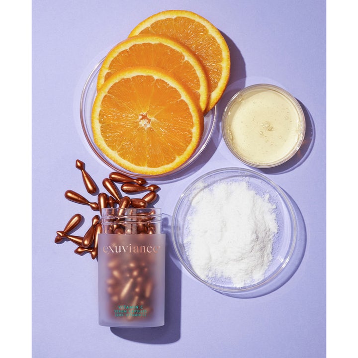 Exuviance Vitamin C Serum Capsules 60 stk giver glød med bronzefarvede kapsler, appelsinskiver og hvidt pulver.