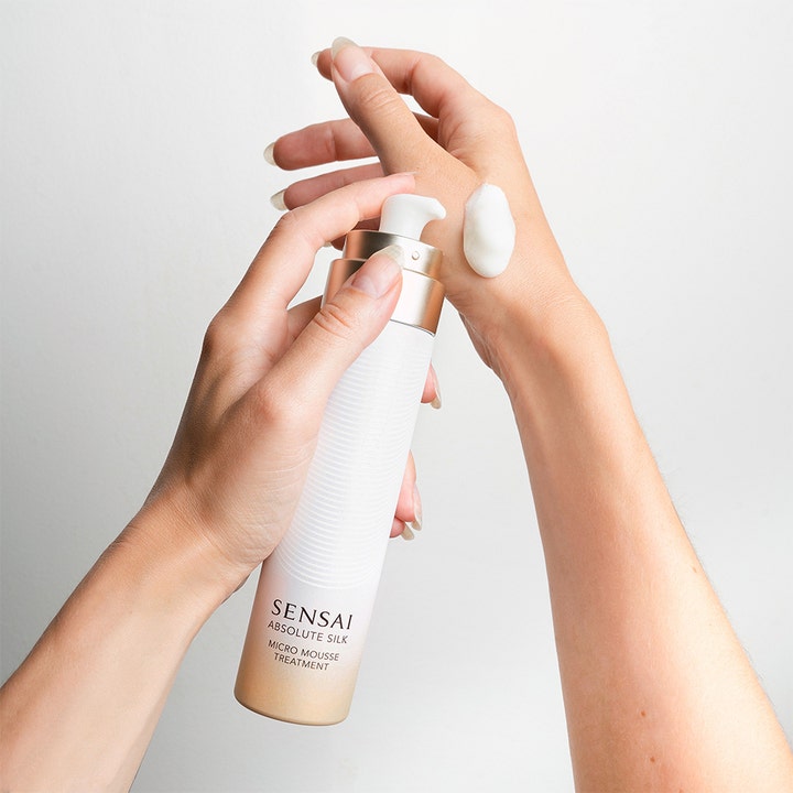 Sensai Absolute Silk Micro Mousse Treatment 90 ml fugtgivende toner med hvid moussetekstur på hånd fra guldflaske.