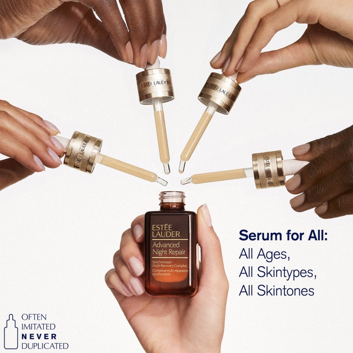 Estée Lauder Advanced Night Repair Serum 50 ml i brun glasflaske holdt af hænder med forskellige hudtoner.