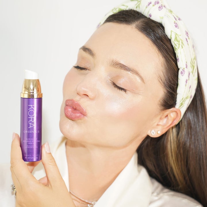 KORA Organics Noni Night AHA Resurfacing Serum 30 ml eksfolierende natserum holdt af kvinde med glød