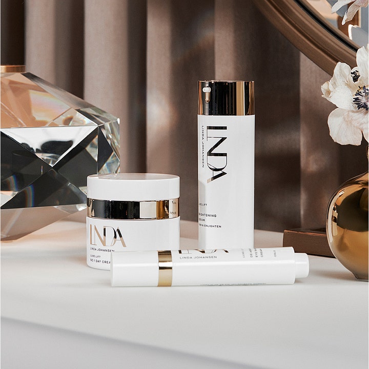 Linda Johansen Skincare Luxe Lift Brightening Serum 30 ml opstrammende serum i hvid pumpeflaske med guld i luksuriøs setting.