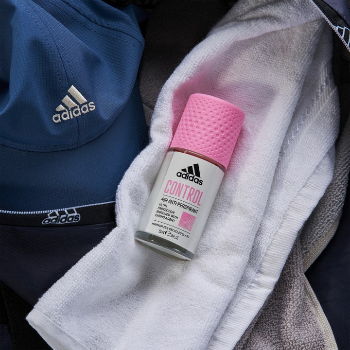 Adidas Control Roll-on Deodorant 50 ml mod sved i glasflaske med lyserødt låg liggende på et hvidt træningshåndklæde