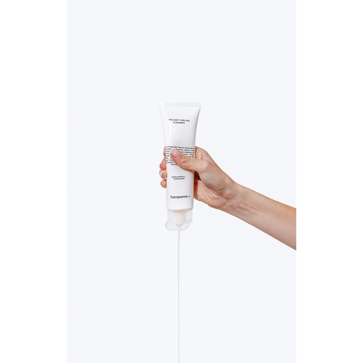 Niche Beauty Lab Transparent Lab pHa Soft Peeling Cleanser 150 ml ansigtsrens der flyder fra en hvid tube i en hånd