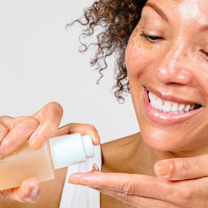 PÜR Ceratin Booster Age Defying Retinol Serum 30 ml modvirker rynker. En kvinde pumper den klare gel ud på fingeren.