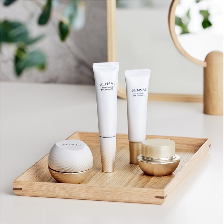 Sensai Total Eye Treatment 35 ml øjencreme og essence i hvide tuber og krukker placeret på en træbakke