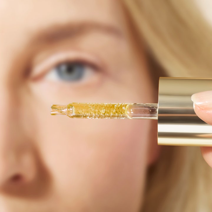 Nuxe Super Serum [10] Eye 15 ml opstrammende øgonserum viser gyldne mikrokapsler i en glaspipette med guldhætte