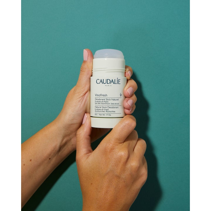Caudalie Vinofresh Stick Deodorant 50 ml giver naturlig beskyttelse i en hvid stift holdt mod en grøn baggrund