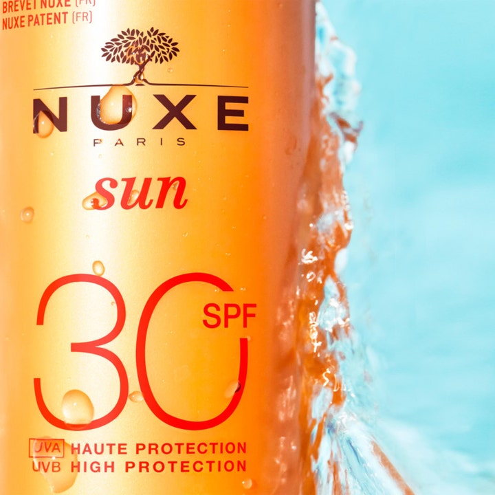 Nuxe Sun Spray 184 g beskyttende SPF30 solcreme i orange flaske med vandstænk og High Protection tekst