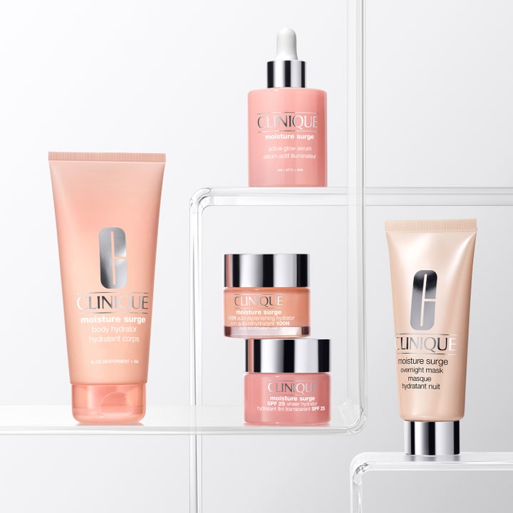 Clinique Moisture Surge Body Hydrator 200 ml fugtgivende bodylotion i ferskenfarvet tube vist med andre produkter.