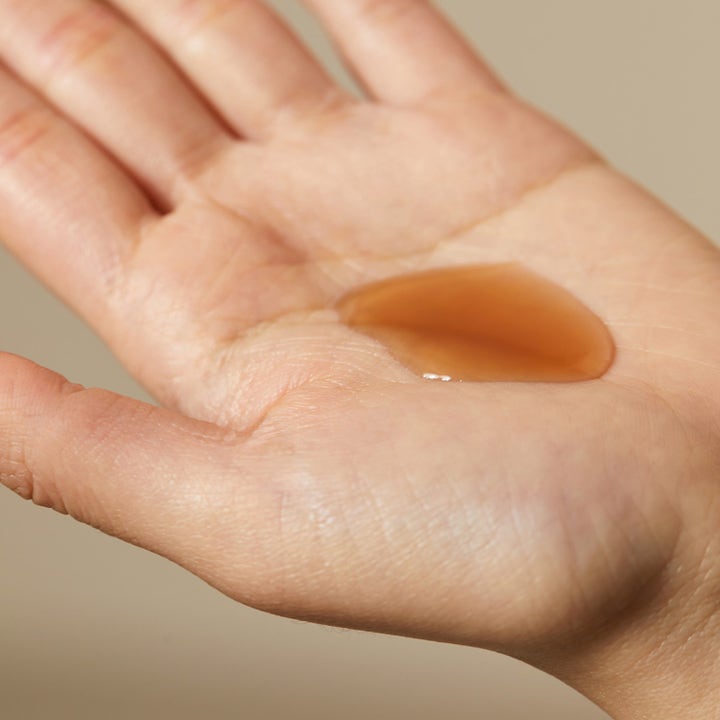 Hyggee Natural Repair Serum 30 ml reparerende ansigtsserum med ravfarvet flydende tekstur i en åben håndflade