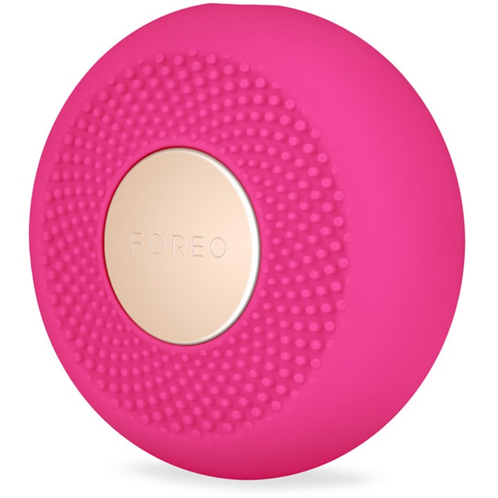 FOREO UFO mini 2 Fuchsia beauty tech giver glød med en rund pink silikone-enhed med nubret tekstur og guldplade