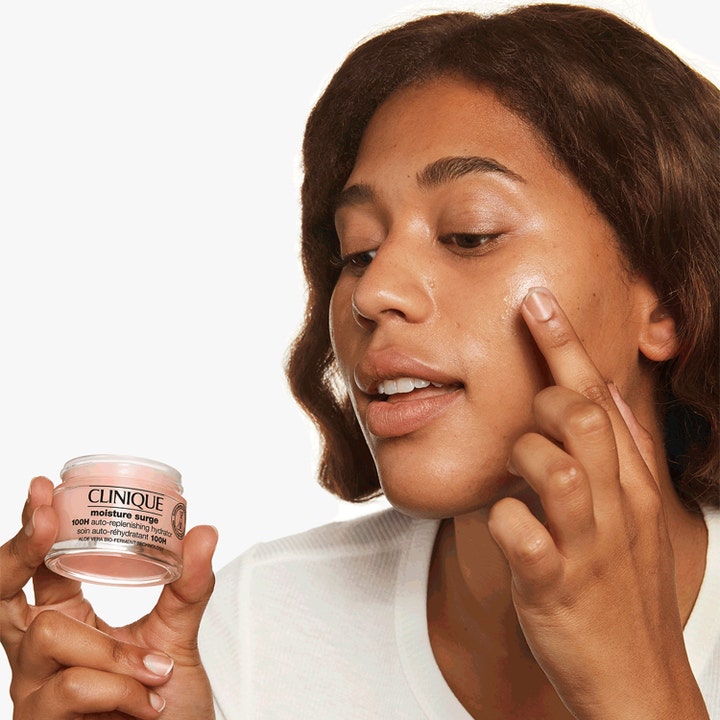 Clinique Moisture Surge 100H 75 ml fugtgivende ansigtscreme påføres på kinden fra en lille glaskrukke